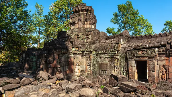 Zrujnowana gopura świątyni Banteay Prei z płaskorzeźbami, otoczona drzewami