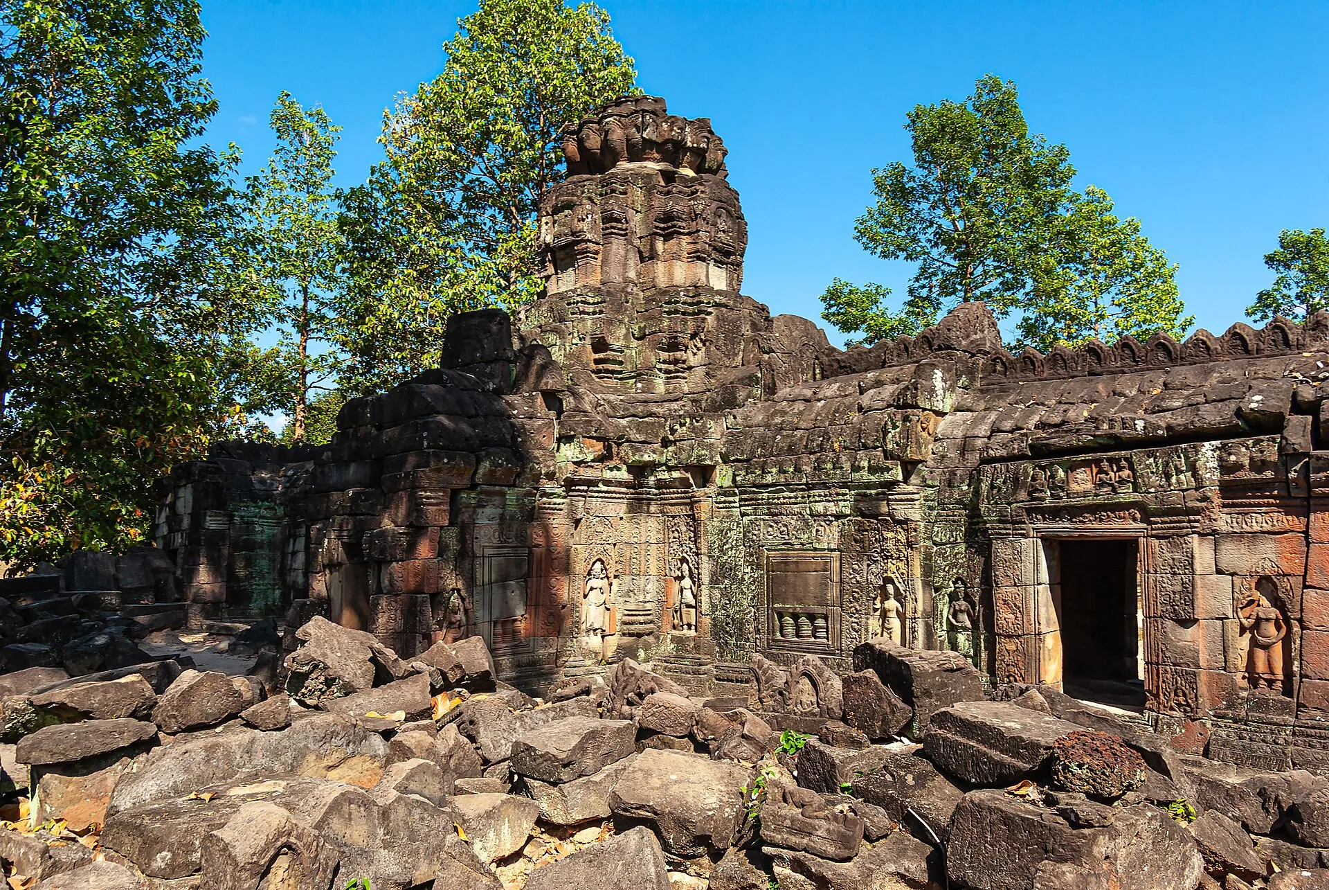 Zrujnowana gopura świątyni Banteay Prei z płaskorzeźbami, otoczona drzewami