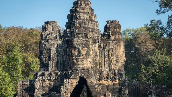 Południowa brama Angkor Thom: wieża z kamiennymi twarzami nad przejściem w murze miasta