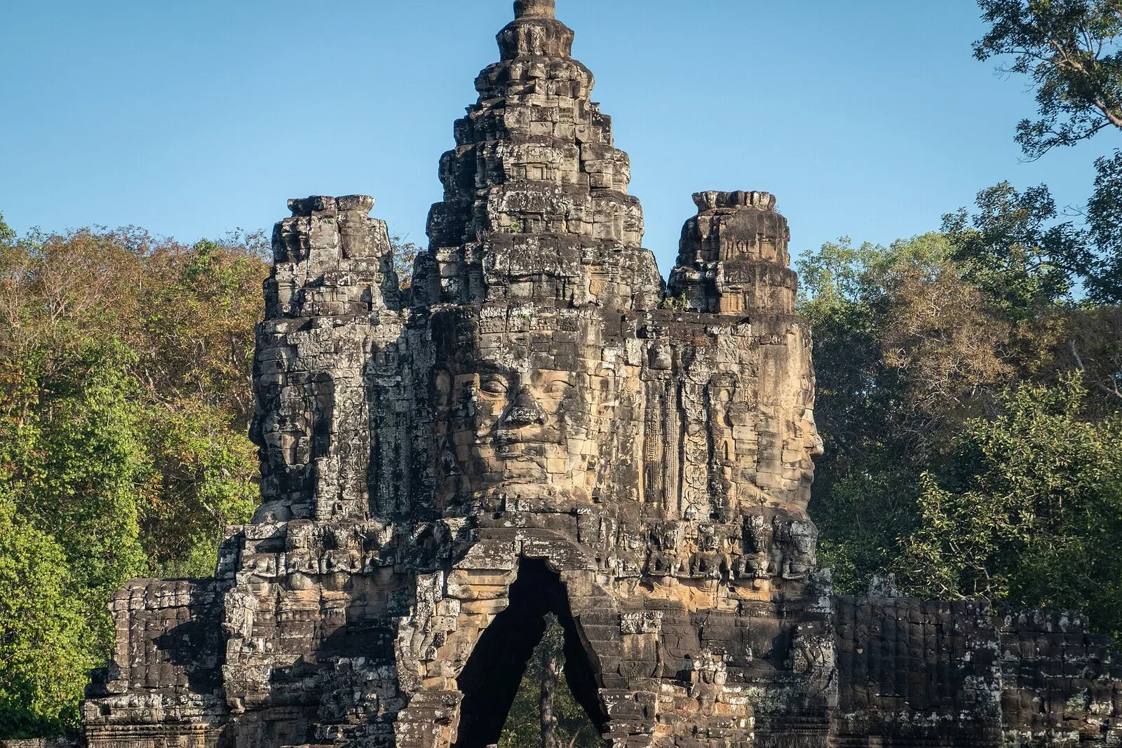 Południowa brama Angkor Thom: wieża z kamiennymi twarzami nad przejściem w murze miasta