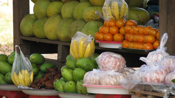 Stragan z pomelo, bananami i pomarańczami na targu przy drodze w Kambodży