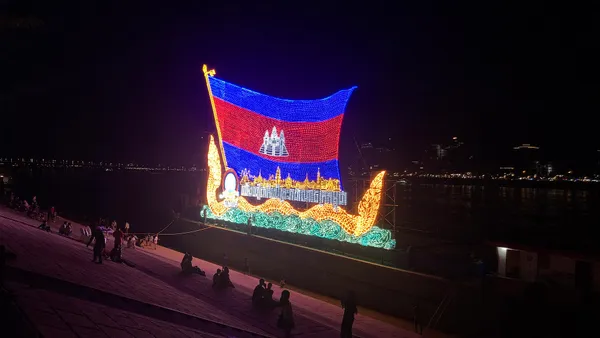 Oświetlona łódź z kambodżańską flagą podczas Festiwalu Wodnego w Phnom Penh