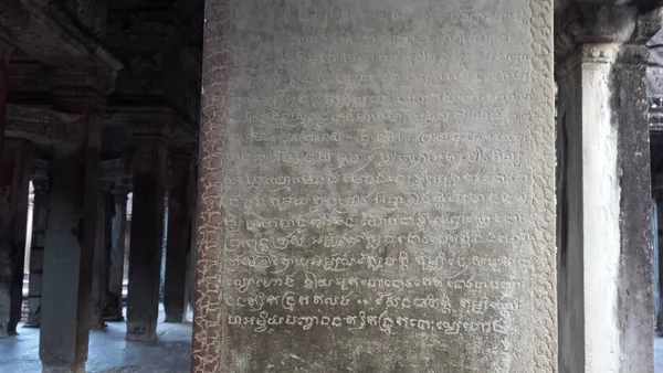 Kamienny filar w galerii Angkor Wat pokryty kilkunastoma wierszami inskrypcji w piśmie khmerskim