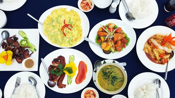 Stół z daniami kuchni khmerskiej: curry, omlet, smażone mięso i ryba, sosy i miseczki ryżu