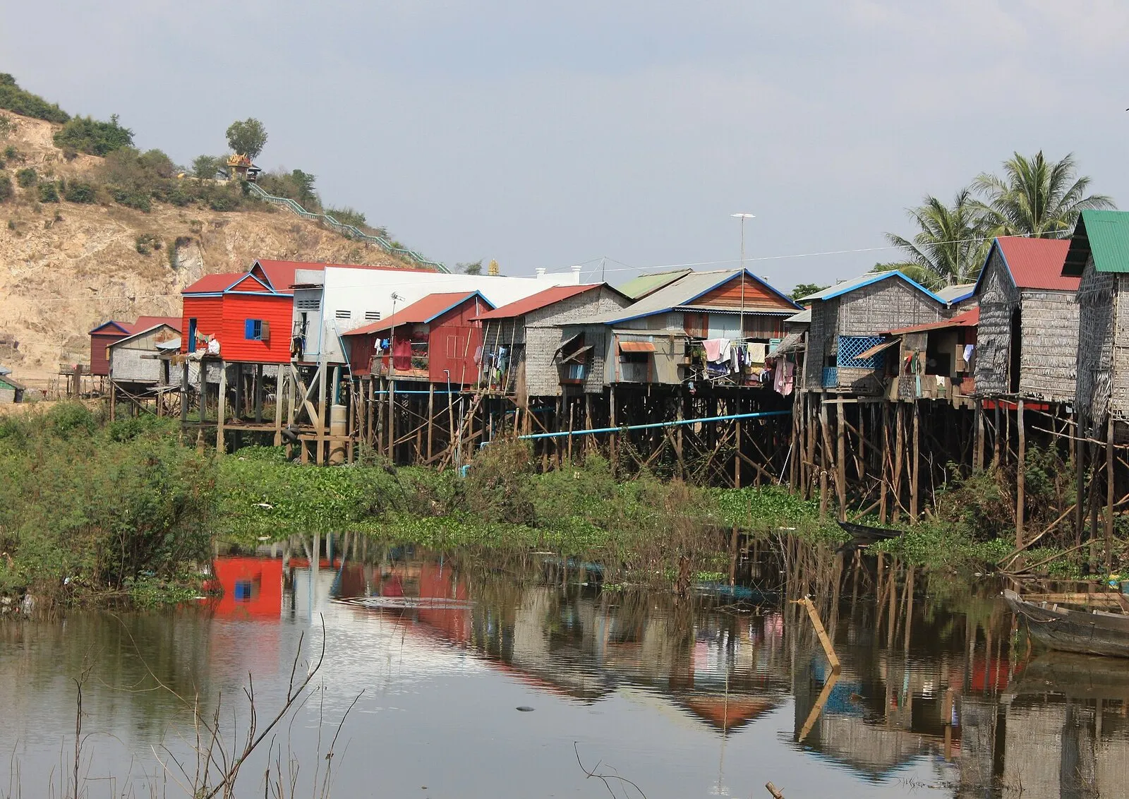 Drewniane i blaszane domy na palach nad rozlewiskiem we wsi przy drodze z Siem Reap nad jezioro Tonle Sap