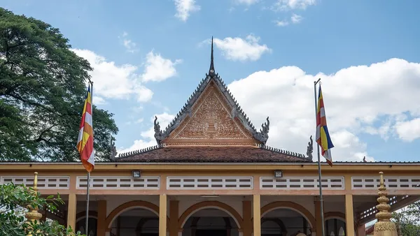 Sala modlitw pagody Wat Damnak w Siem Reap z dwiema buddyjskimi flagami na masztach