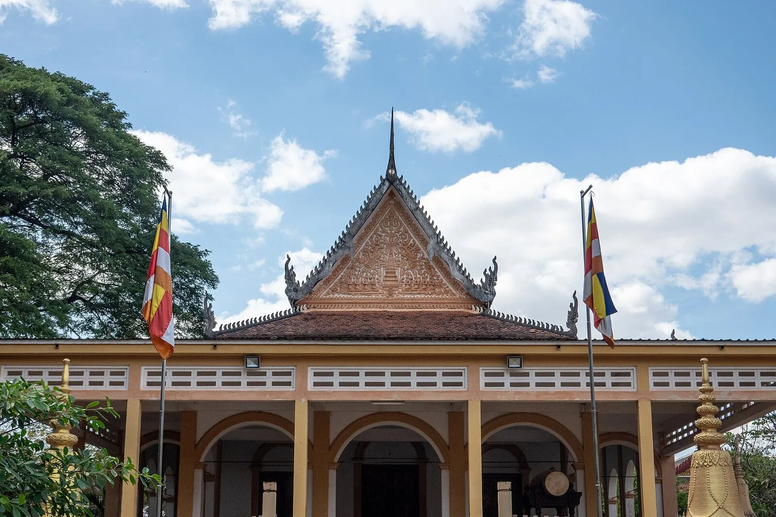 Sala modlitw pagody Wat Damnak w Siem Reap z dwiema buddyjskimi flagami na masztach