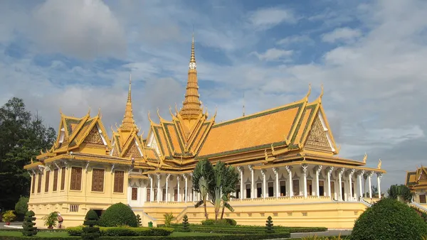 Sala Tronowa Pałacu Królewskiego w Phnom Penh ze złoconymi dachami i iglicą, przed nią strzyżony ogród