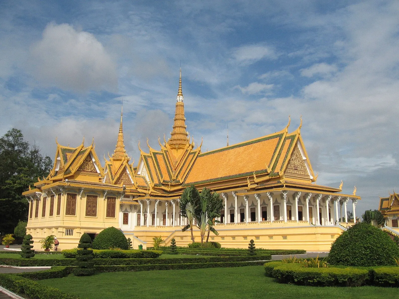 Sala Tronowa Pałacu Królewskiego w Phnom Penh ze złoconymi dachami i iglicą, przed nią strzyżony ogród
