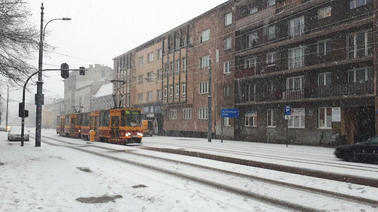Tramwaj na zaśnieżonej ulicy Piotrkowskiej w Łodzi podczas opadów śniegu