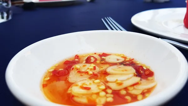Miseczka słodzonego sosu rybnego z czosnkiem i siekanym chili, podanego jako dip w restauracji w Kambodży