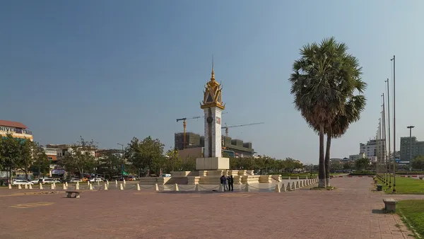 Pomnik Przyjaźni Kambodżańsko-Wietnamskiej na placu w Phnom Penh, obok wysoka palma
