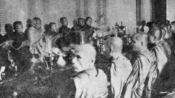 Czarno-białe zdjęcie mnichów buddyjskich siedzących w sali Instytutu Buddyjskiego w Phnom Penh w 1930 r.