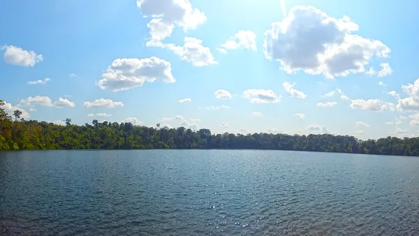 Panorama kraterowego jeziora Yeak Laom otoczonego lasem