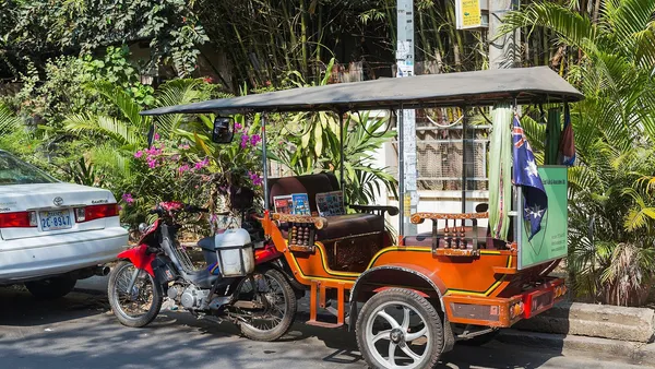 Pomarańczowy tuk-tuk zaparkowany przy ulicy w Phnom Penh