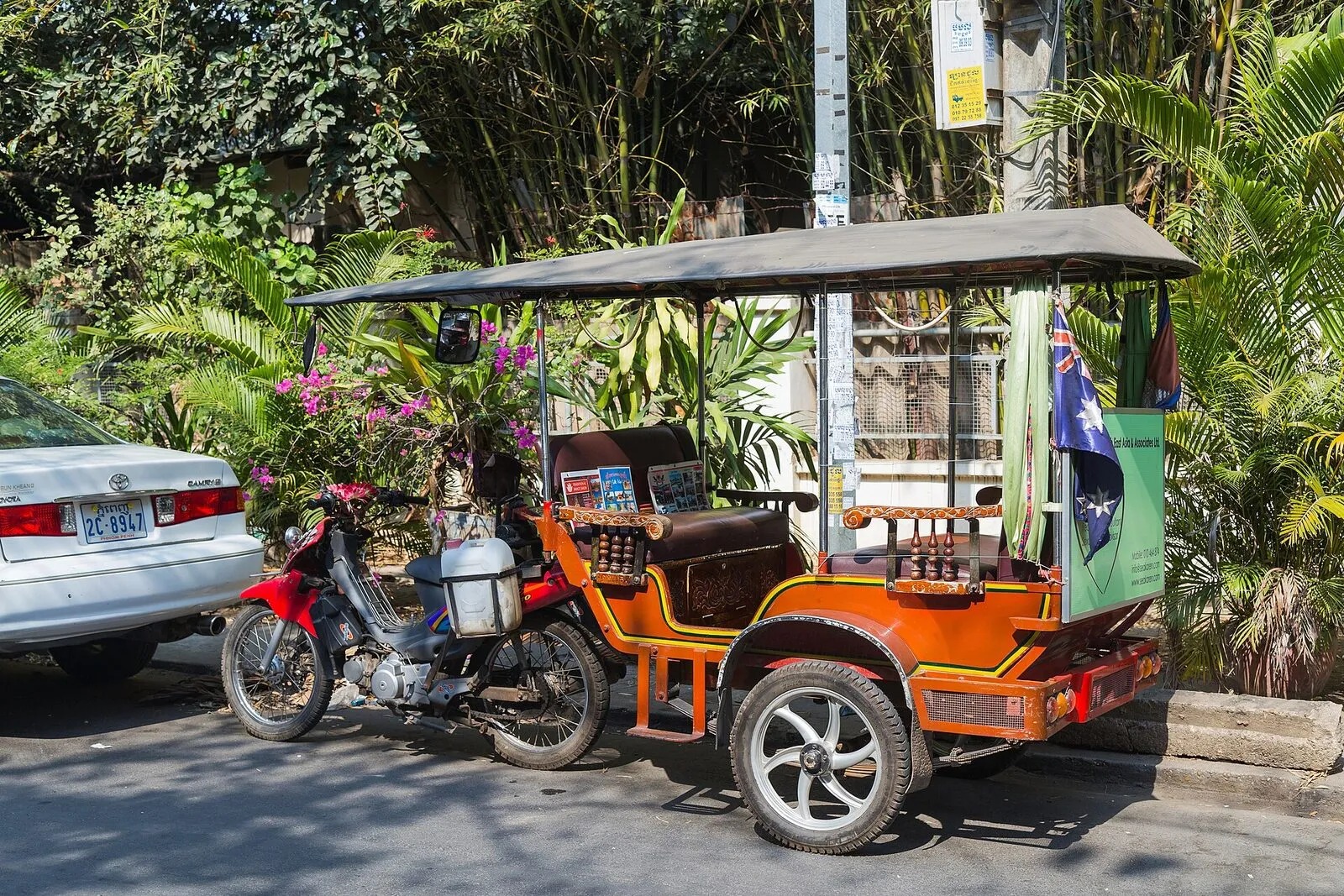 Pomarańczowy tuk-tuk zaparkowany przy ulicy w Phnom Penh