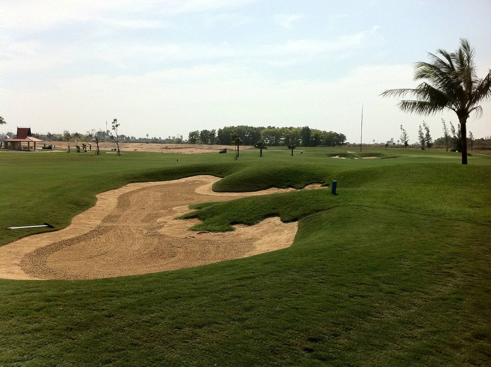 Fairway z bunkrem piaskowym i palmami na polu Grand Phnom Penh Golf Club pod Phnom Penh