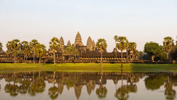 Wieże Angkor Wat wśród palm odbite w stawie przed świątynią