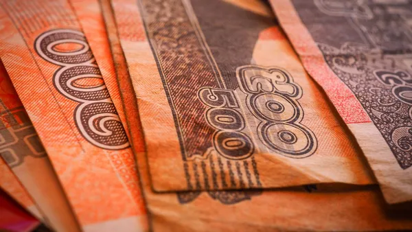 Zbliżenie na wachlarz pomarańczowych banknotów 500 rieli