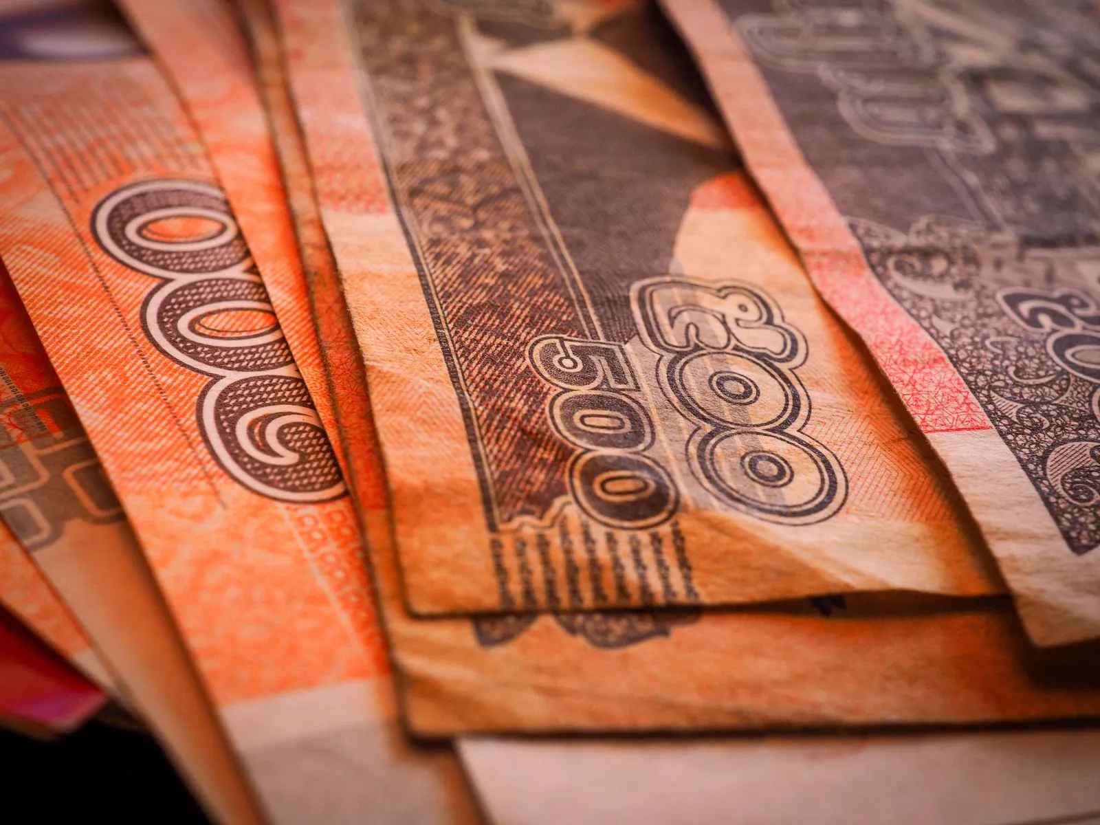 Zbliżenie na wachlarz pomarańczowych banknotów 500 rieli